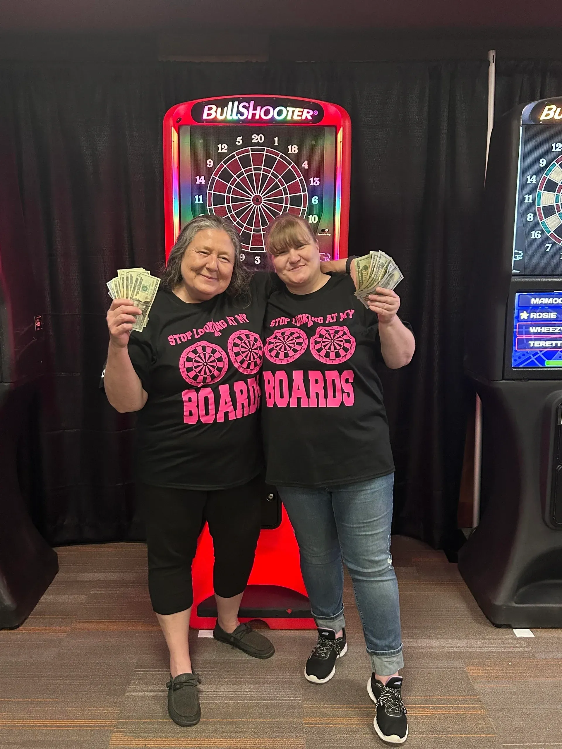 Smiling women in matching shirts with money