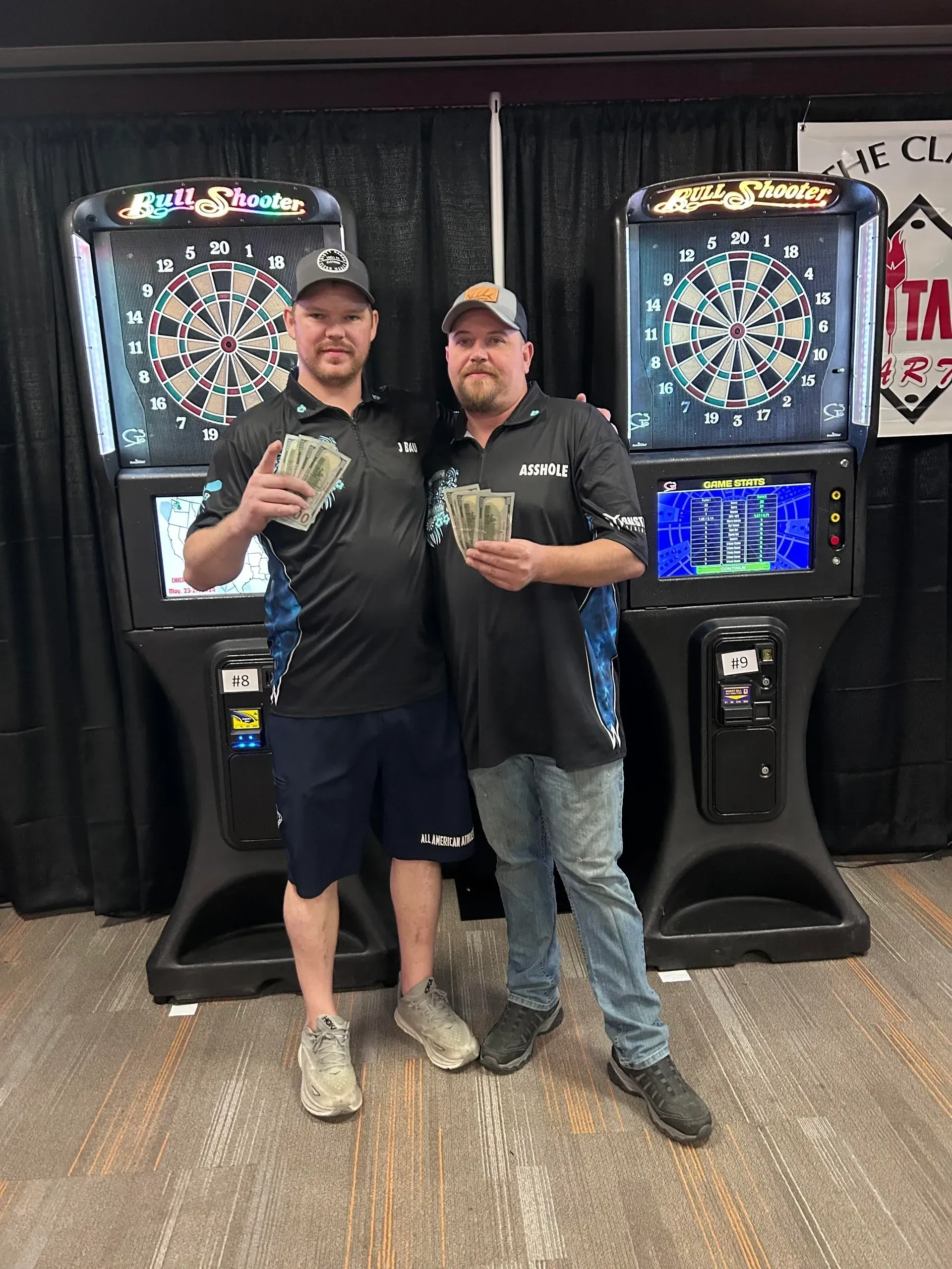 Dart players celebrate with prize money.