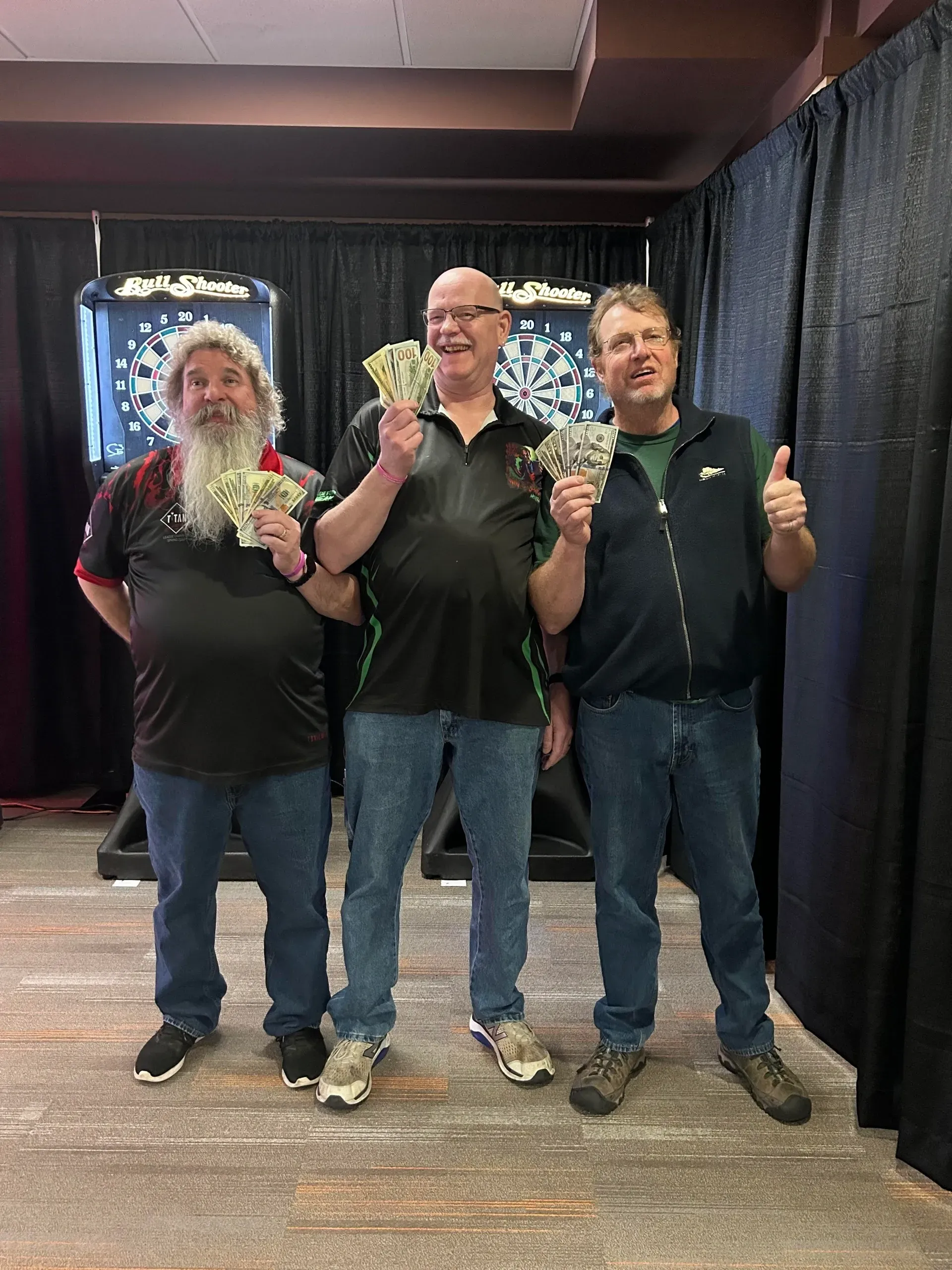 Happy men posing with winnings at darts event