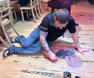 Man organizing coins on wooden floor