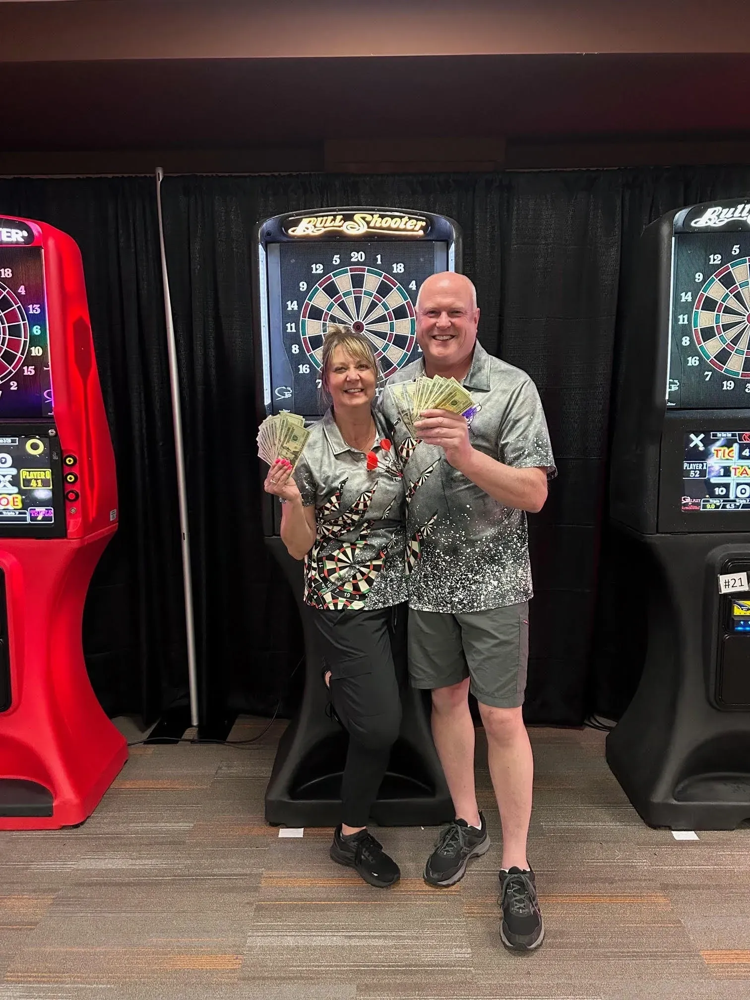 Two people celebrating with cash at arcade