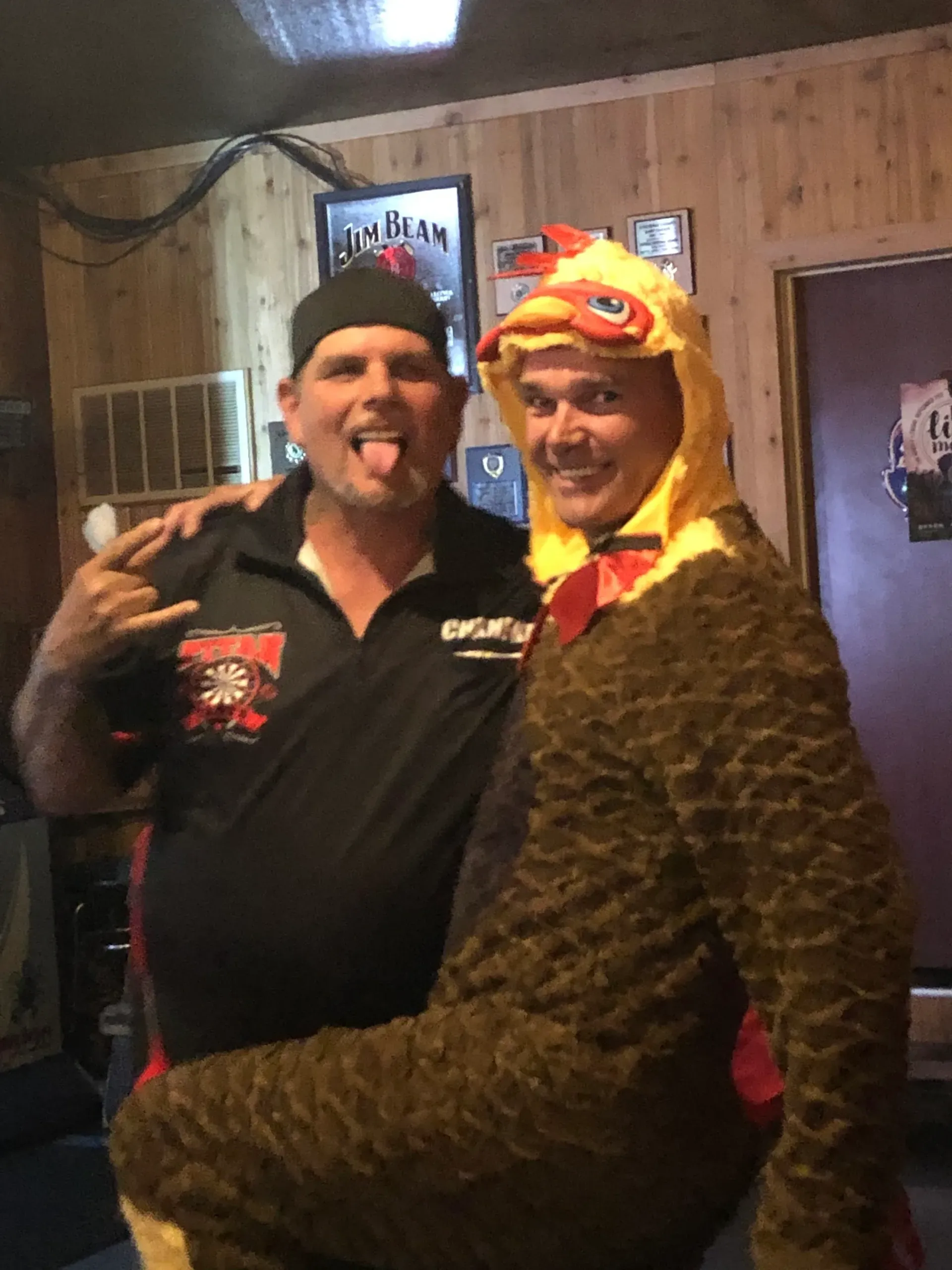 Two men posing, one in chicken costume