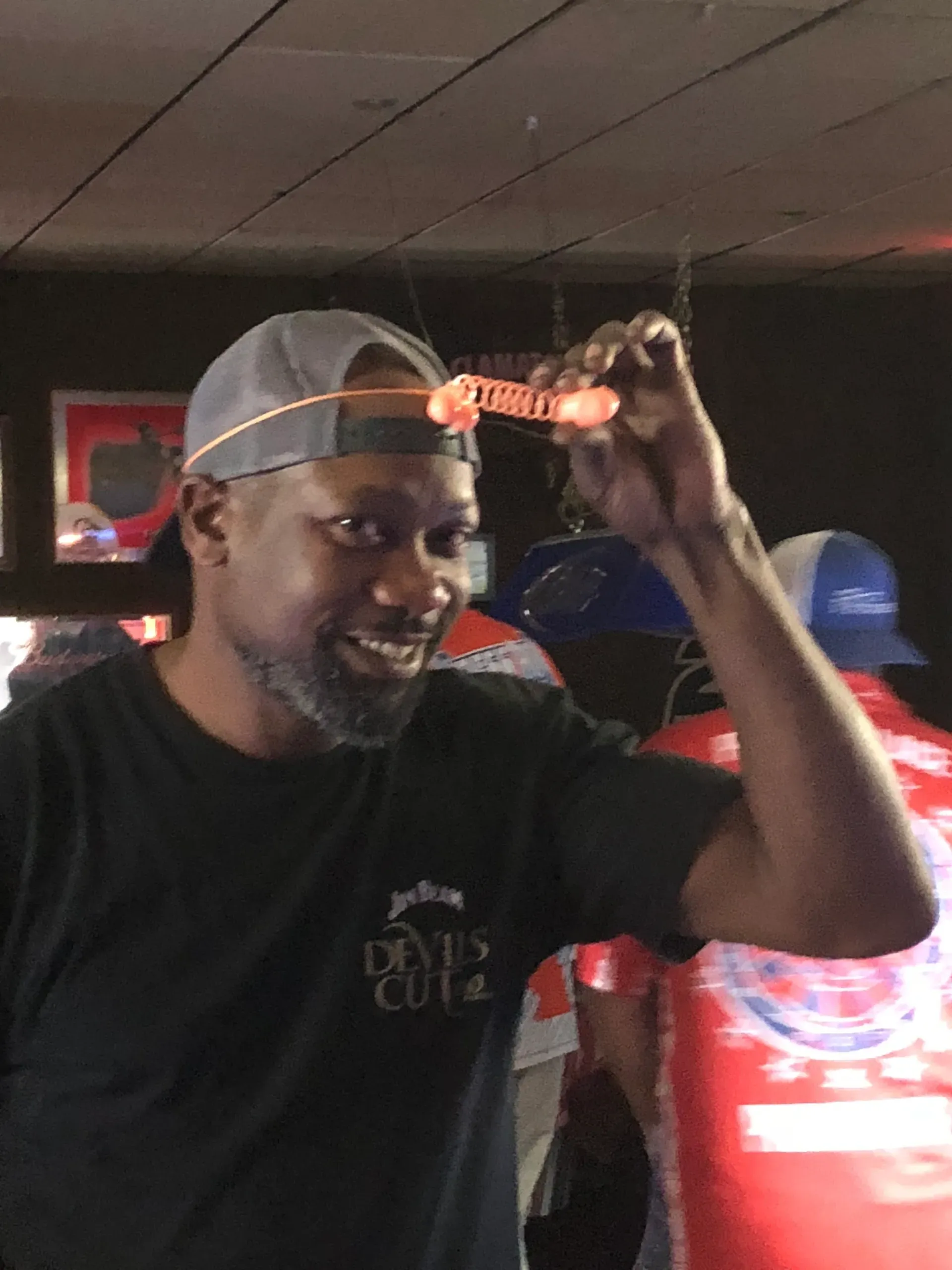 Person wearing cap, holding novelty glasses