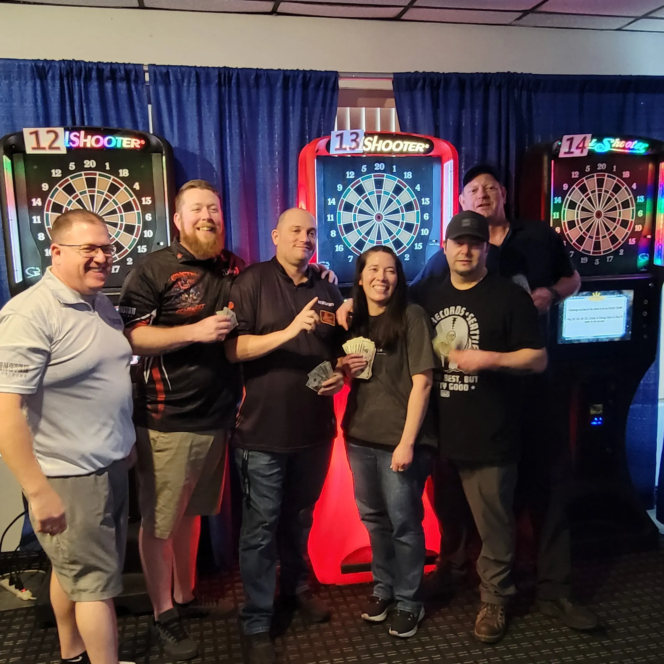 Group celebrating at dartboard tournament